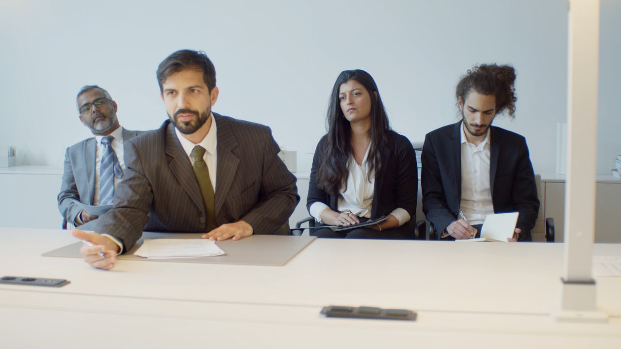 Home A diverse group of business professionals in a modern office setting, focusing on teamwork.